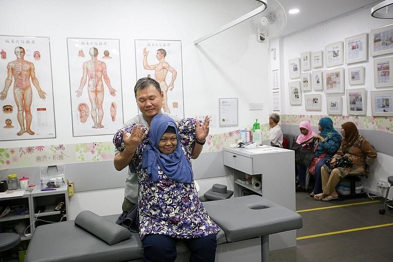 TCM therapist Lam Kean Lung treating Madam Kamisah at a Sian Chay Medical Institution clinic in Geylang. The 62-year-old, who was suffering from frozen shoulder pains, could raise her arms again after two sessions. Sian Chay has grown from one clinic