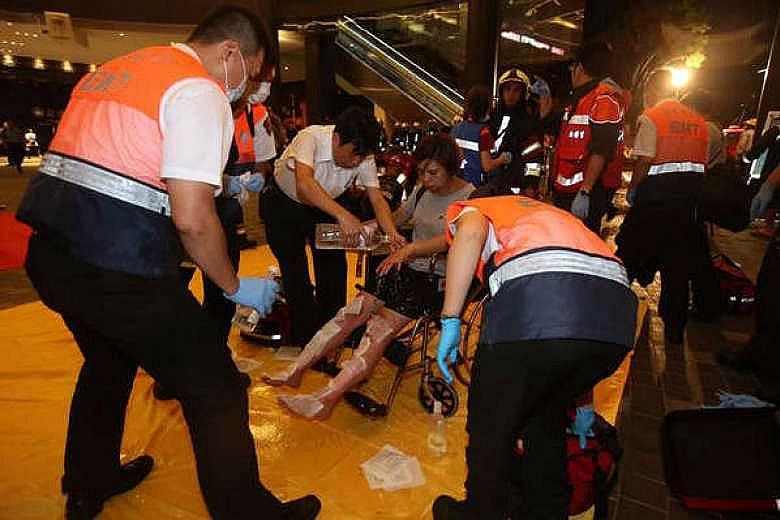 Above: A member of a bomb squad inside the train carriage. Witnesses say they saw a man leaving a bag in the cabin moments before the explosion. Left: Emergency service staff tending to an injured passenger after a blast on board a train in Taipei's 