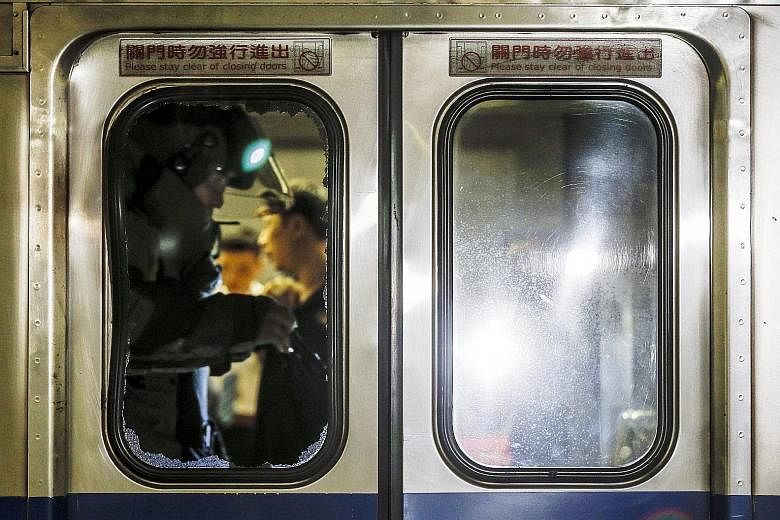 Above: A member of a bomb squad inside the train carriage. Witnesses say they saw a man leaving a bag in the cabin moments before the explosion. Left: Emergency service staff tending to an injured passenger after a blast on board a train in Taipei's 