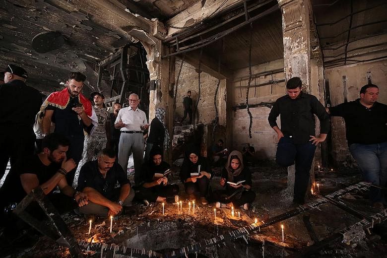 Iraqis praying on Wednesday at the site of a suicide bombing attack which took place on Sunday in Baghdad's Karrada neighbourhood. At least 280 people were killed. Many Iraqis blame their suffering on bad decisions made by the US and Britain.