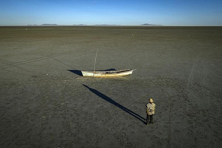 Indigenous leader Emilio Huanaco Choque cuts a lonely figure in the dry bed of Lake Poopo outside of Llapallapani, Bolivia. The lake, once Bolivia's second largest, is now just a dry, salty expanse due to climate change.