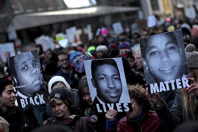 Demonstrators in New York holding posters of Michael Brown (from left), Eric Garner and Tamir Rice in December 2014, during a march to protest against their deaths.