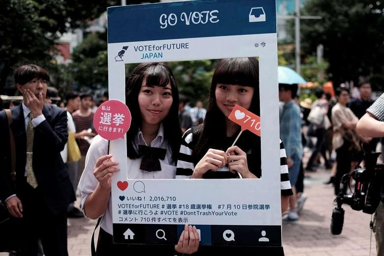High school students in Tokyo with a cardboard Instagram frame calling on the youth to vote in tomorrow's Upper House elections. Last year, Japan lowered the voting age to 18 from 20 - the first change since 1945, when the voting age was revised to 20 fro
