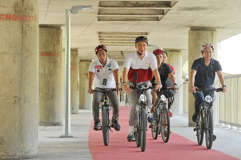 PM Lee, LTA chief executive Chew Men Leong (far right) and Dr Koh Poh Koon (behind, partially hidden), an MP for Ang Mo Kio GRC, taking a ride on the 4km-long cycling path that loops around Ang Mo Kio Avenues 1, 3 and 8. Cycling paths are painted red