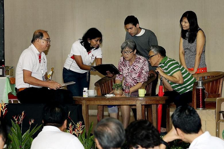 Pioneer Generation Office staff performing a skit of a home visit at a dinner for volunteers in the Ang Mo Kio and Sengkang West areas.