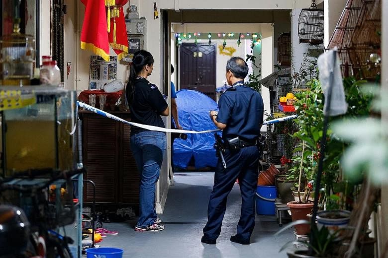 Police officers examining the area where a 52-year-old's bloody body was found near a coffee shop in Geylang Lorong 23 yesterday morning. The dead man was said to be a former helper at a stall in the coffee shop. In Yishun, a 26-year-old man was foun