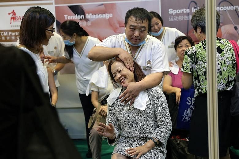 A visitor to the 12th annual Health & You Exhibition getting a free massage yesterday. The two-day health and wellness exhibition, organised by The Straits Times' Mind & Body and Lianhe Zaobao's Lohas, features 80 exhibitors. It runs from 9am to 9pm 