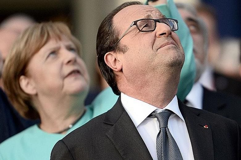 French President Francois Hollande and German Chancellor Angela Merkel at a fly-past of Nato countries' jet fighters at the summit in Warsaw, Poland, on Friday.