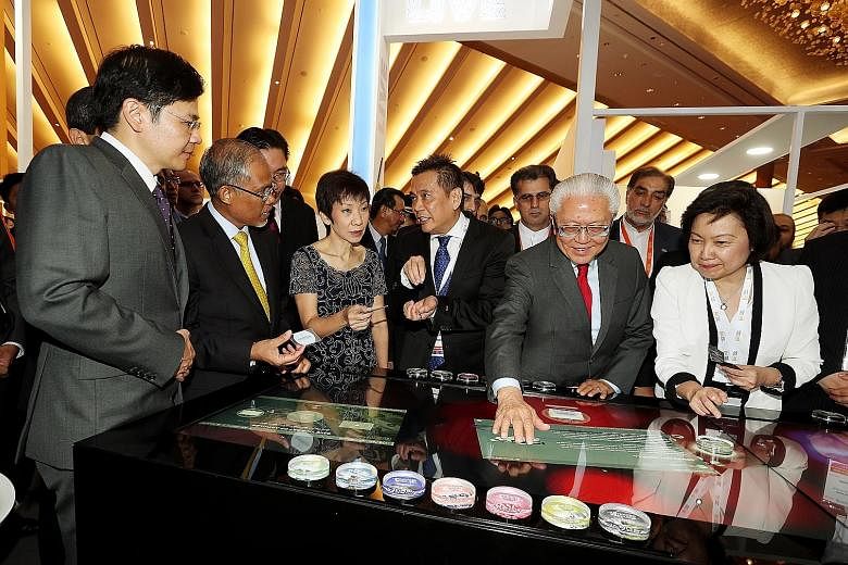 President Tan engaging with a multitouch Smart Table at the opening of the World Cities Summit, Singapore International Water Week and CleanEnviro Summit Singapore. With him are (from left) National Development Minister Lawrence Wong, Environment and