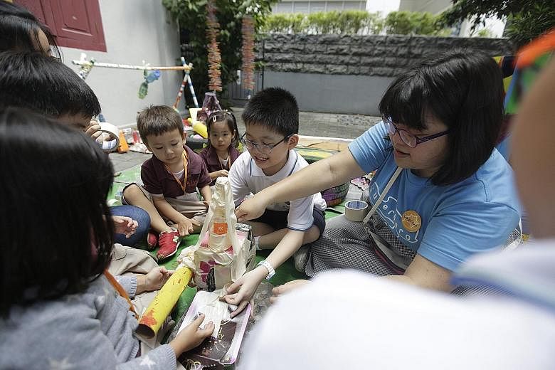 Superhero Me facilitator Chen Weiyan helping kids from Pathlight School (in white) and Odyssey The Global Preschool build a rocket from recycled materials at the Planet of Possibility exhibition.