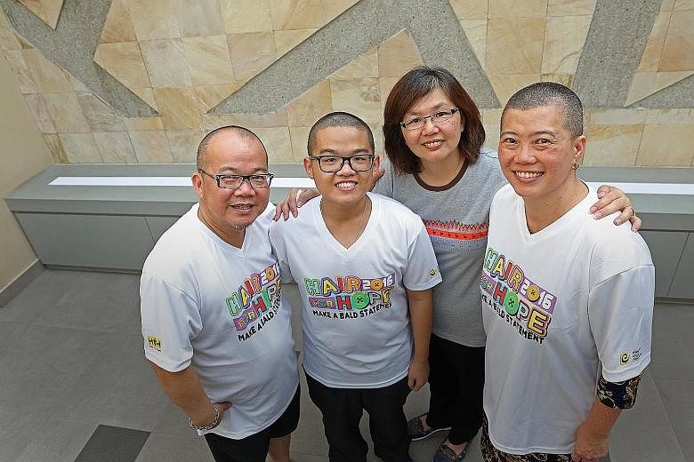 Childhood cancer survivor Jarenn Foo, now 19, with his father Zaric, 51, mother Maria Lim (wearing grey), 49, and Prof Chan (right), who shaved her head in solidarity with the younger Mr Foo.