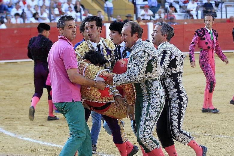 Above: Spanish bullfighter Victor Barrio being gored during a bullfight in Teruel. Left: Mr Barrio being carried out of the bullring. He was pronounced dead at the scene, the bullfight organiser said.
