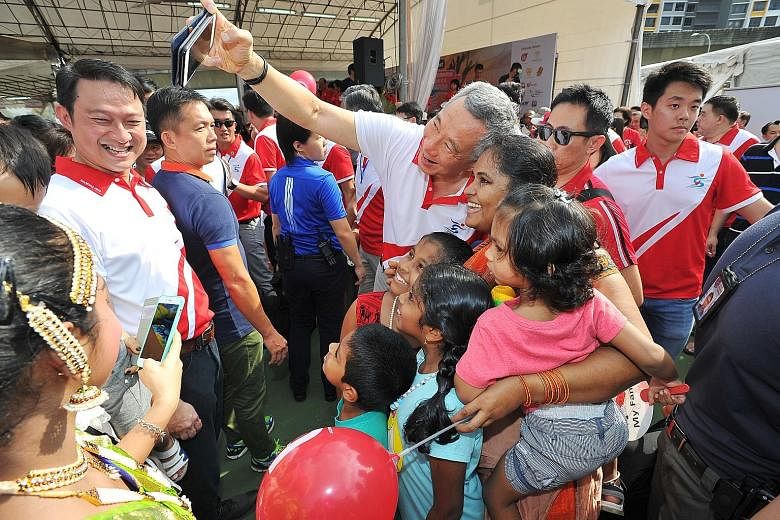 PM Lee taking a wefie with residents at Sengkang West's 10th anniversary carnival celebrations near Anchorvale Community Club yesterday. Dr Lam (left), MP for the single ward, said that, among other improvements, there will be higher frequencies of M