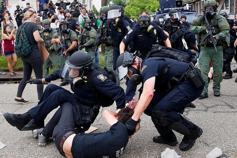A demonstrator is detained by police officers during protests in Baton Rouge, Louisiana, on Sunday. A similar protest happened in St Paul, Minnesota, around the same time. Both demonstrations were over the police shootings of young black men in those