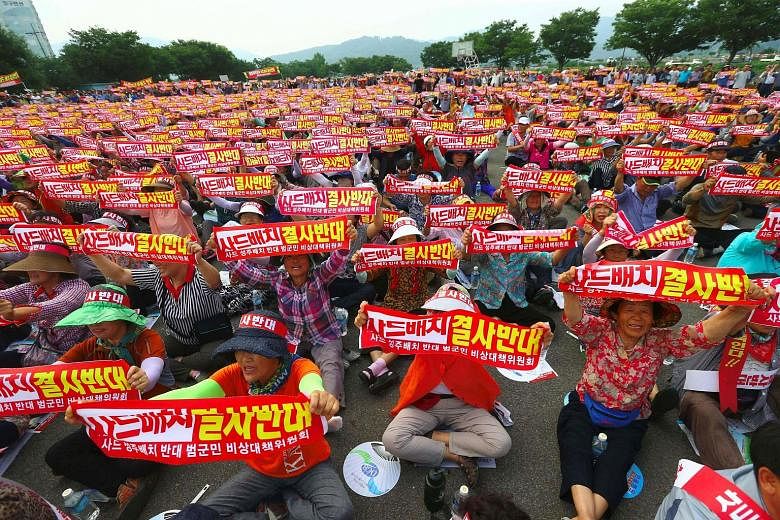 Thousands of South Koreans holding up banners reading "We absolutely oppose Thaad deployment" during a rally yesterday against the planned deployment of the US-built Terminal High Altitude Area Defence system in Seongju. The system, meant to defend a