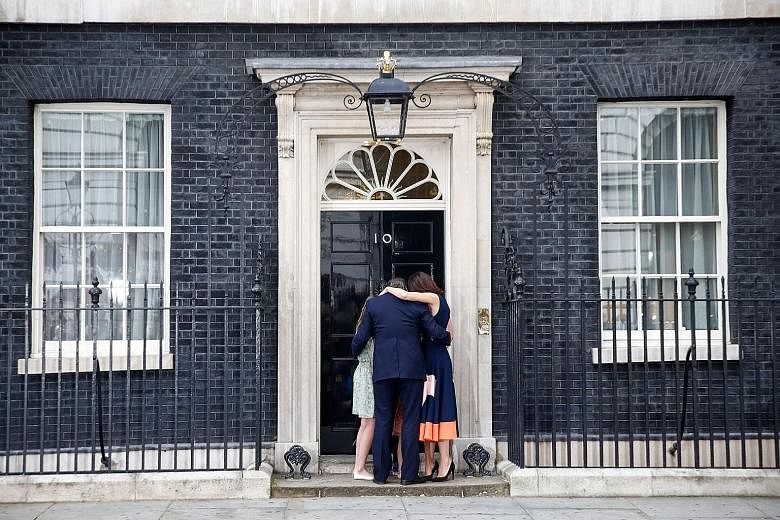 Mr Cameron sharing an embrace with his wife Samantha and children Nancy, Elwen and Florence outside No. 10 Downing Street, the official residence of the British Prime Minister, yesterday.