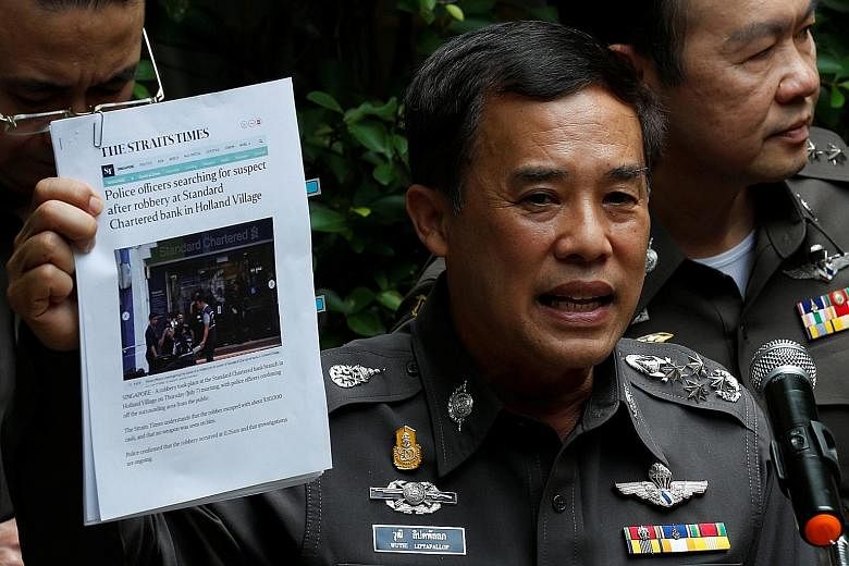 Above: Roach, 27, was arrested at a hostel in Bangkok on Sunday, after a two-day manhunt by the Thai police. Right: Thai deputy national police chief Wuthi Liptapallop, with a copy of a Straits Times report about last Thursday's bank robbery, at a ne