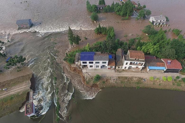 Houses are flooded as a dyke is breached this week in Huarong County, in Hunan Province, on the southern bank of the Yangtze River. Water levels in the middle and lower reaches of great river are falling, but most remain above warning levels.