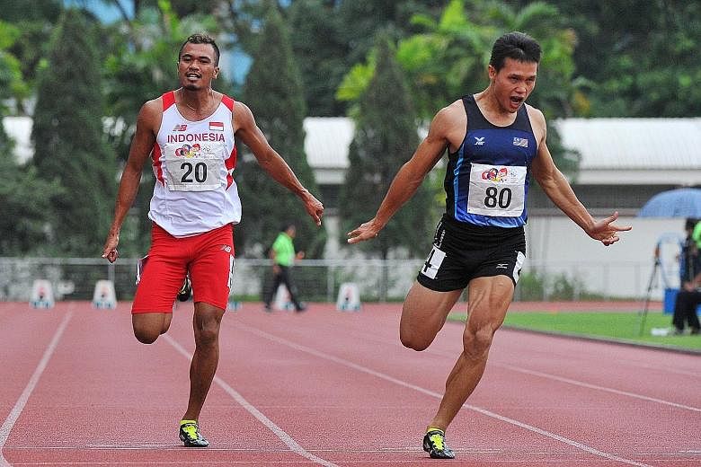 Jonathan Nyepa (right) of Malaysia winning gold in the Asean University Games 100m in 10.62sec at Choa Chu Kang Stadium yesterday. Indonesia's Iswandi Iswandi (No. 20) won the bronze behind Vietnam's Le Trong Hinh.