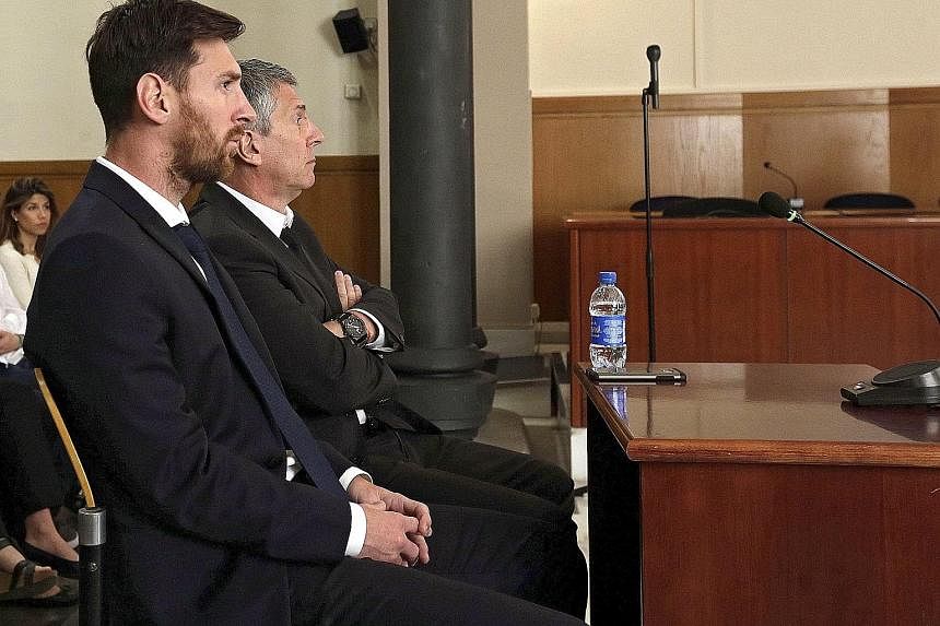 Barcelona's Lionel Messi (foreground) and his father Jorge attending a session of their tax fraud trial last month. They were sentenced to 21 months in prison last week, which prompted the club to start an online solidarity campaign in support of the