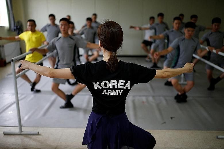 South Korean soldiers executing plies under the watchful eye of a ballerina during a practice session at a military base near the Demilitarised Zone.