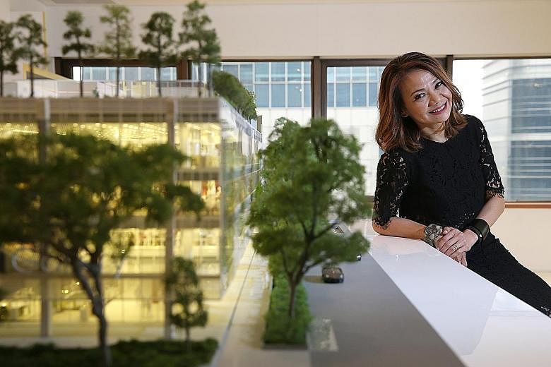 OUE's Ms Tan, seen here next to a model of OUE Downtown, says that besides a "social kitchen", the Downtown Gallery mall will feature an auto deli where people order food using their mobile devices and have it delivered to lockers there.