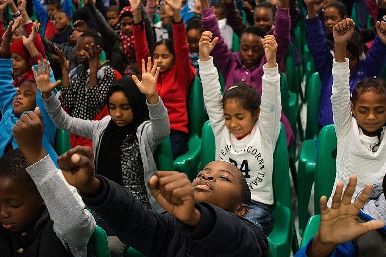 Pupils from a school in Bonteheuwel, a township in South Africa, taking part in a free meditation class. Gang violence in the region often keeps youngsters out of school. Activities like meditation are thought to help these children deal with their h