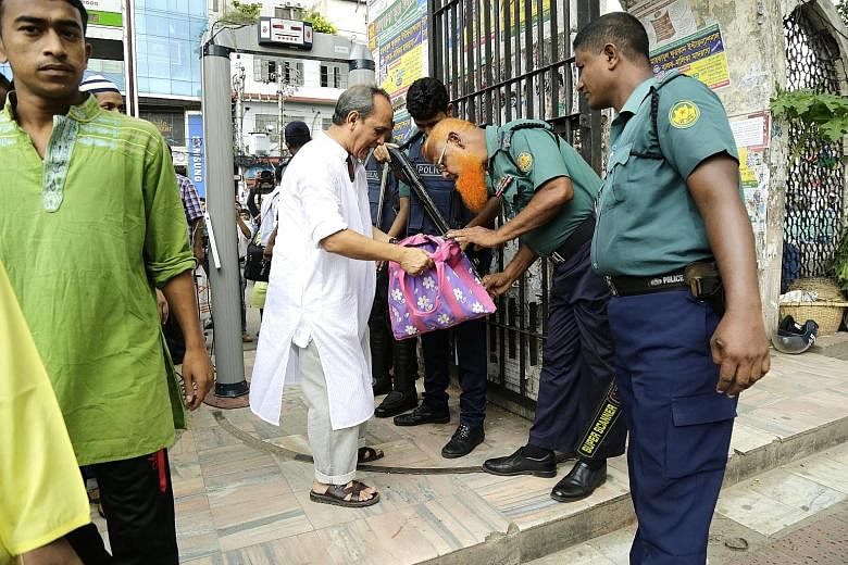 Security officials conducting checks at the entrance of the national mosque in Dhaka yesterday. Bangladesh has stepped up its campaign to combat Islamist extremism after a deadly cafe siege.