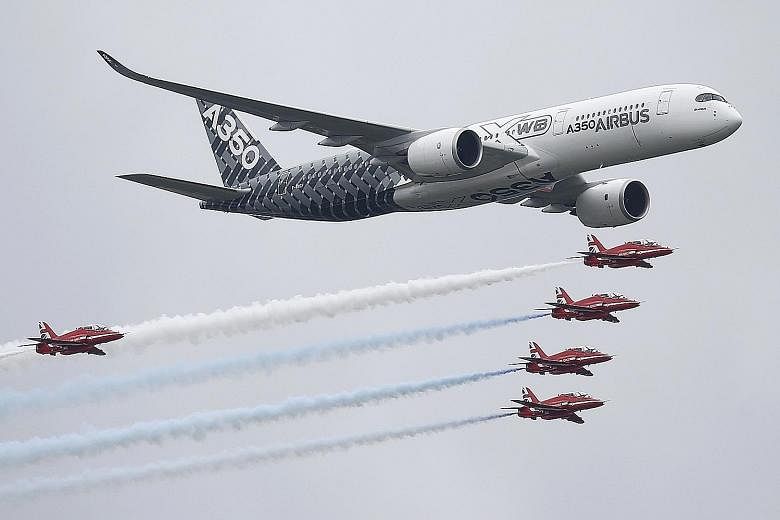 An Airbus A-350 flying with Britain's Red Arrows display team at Farnborough on Friday. The aircraft giant sold 279 planes at the airshow.