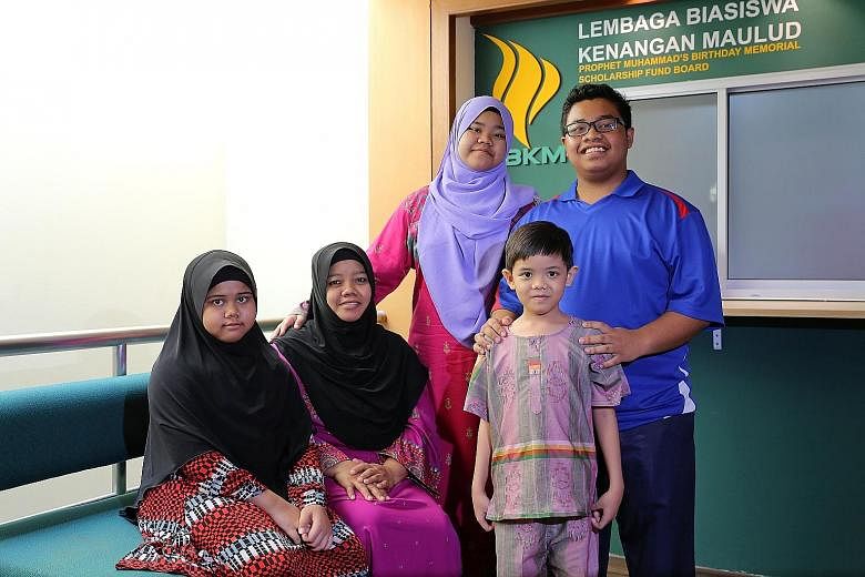 Madam Rohaya (seated, second from left) with her daughters Siti Nur Raudhah (left), 11, and Siti Nur Aisyah, 14, and sons Muhammad Nur Fadhli, 16, and Muhammad Nur Firdhaus, seven. Her husband, the family's main breadwinner, died in a hit-and-run acc