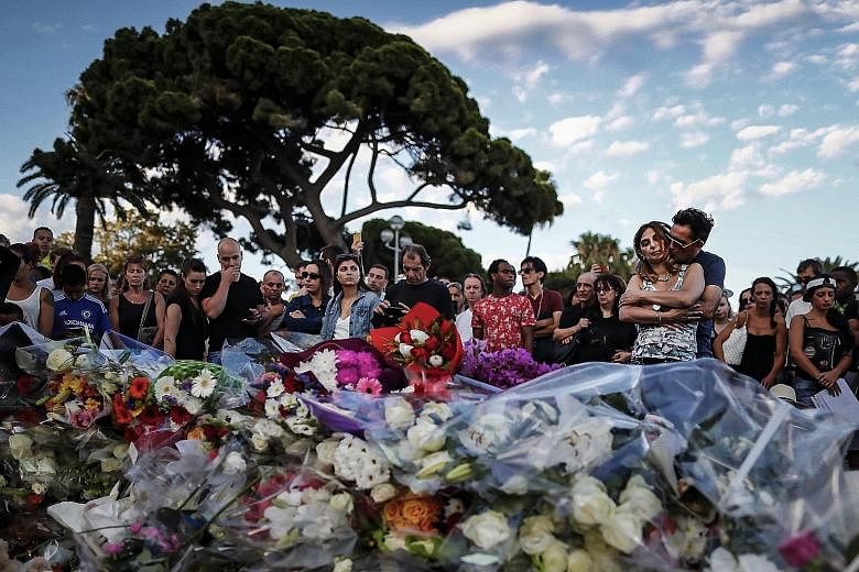 People gathering in front of the memorial set on the Promenade des Anglais where the truck crashed into crowds during the Bastille Day celebrations, in Nice, France, on Friday. At least 84 people died and many were wounded.