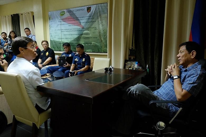 Mr Duterte (right) speaking with Mr Lim during a meeting at the Philippine Drug Enforcement Agency office in Davao. A video of the bizarre meeting was posted on a government YouTube channel yesterday.
