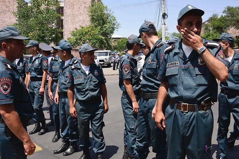 Armenian police officers blocking the streets to Erebuni police station in Yerevan yesterday. One policeman was killed and several were taken hostage when an armed Armenian group with links to a jailed opposition leader seized a police building.