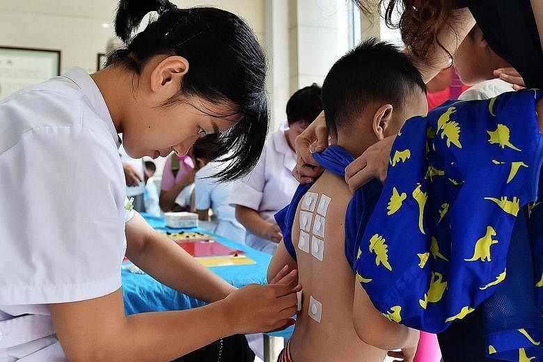 Yesterday was the first day of the san fu, or the hottest period of the year based on the Chinese almanac. At a TCM hospital in Shijiazhuang, Hebei province, a doctor helps to put san fu tie patches on a boy. These patches, which are stuffed with Chi