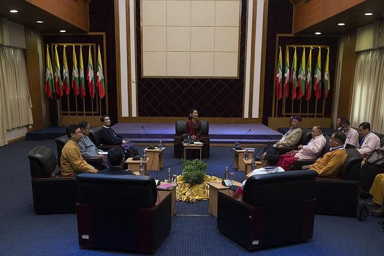 Ms Suu Kyi (centre) discussing the possibility of a ceasefire agreement with the heads of various ethnic-minority militia groups.
