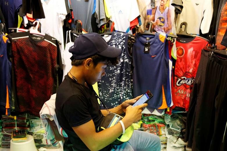A vendor surfing the Internet on his phone in Paranaque, Metro Manila on July 7, 2016.