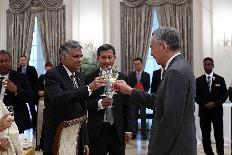 PM Lee and Mr Wickremesinghe toasting each other at the Istana yesterday, with Foreign Minister Vivian Balakrishnan looking on. PM Lee said that when the Singapore-Sri Lanka free trade agreement is completed, it will be a boost for companies and inve