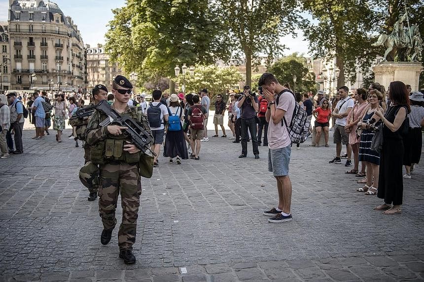 French soldiers on patrol in front of the Notre Dame Cathedral in Paris as the country observed a minute of silence yesterday for the victims of last Thursday's attack in Nice. The attacker, Bouhlel, used a truck to mow down people along Nice's seasi
