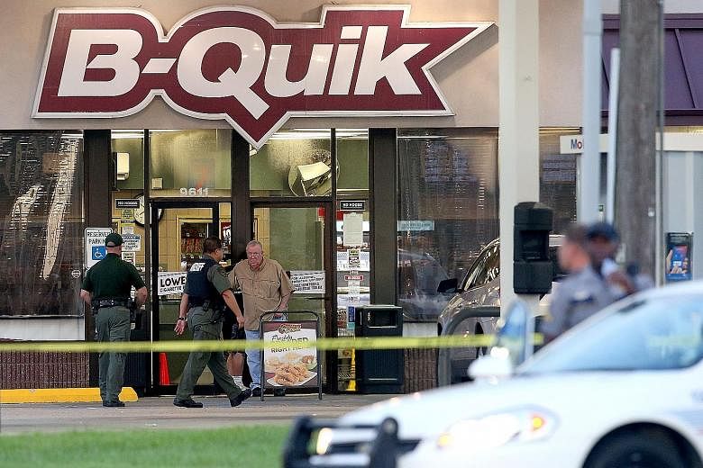 The scene of the shoot-out on Sunday where three police officers were killed by a former US Marine sergeant. Several officers came under fire as police responded to a 911 emergency call about a man dressed in black standing behind a store holding a r