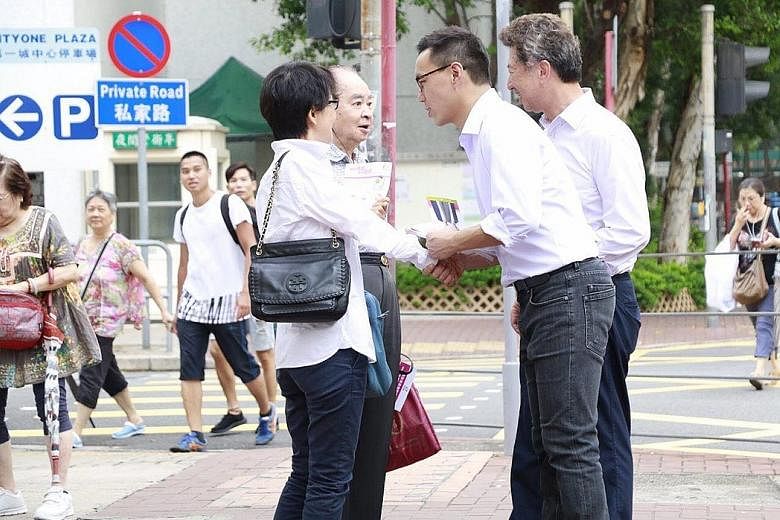 Pan-democrats Ronny Tong (far right) and candidate Raymond Mak campaigning in Sha Tin.
