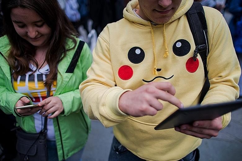 Gamers absorbed in Pokemon Go in the Austrian capital Vienna. The free app uses smartphone satellite location, graphics and camera capabilities to overlay cartoon monsters on real world settings, challenging players to capture and train the creatures