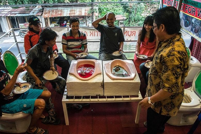 At Jamban Cafe (left), guests sit on upright toilet seats around a table where food is served in squat loos. "Jamban" means toilet in Bahasa Indonesia. On the cafe's menu is meatballs in soup (above). Other places have similar themed restaurants, but
