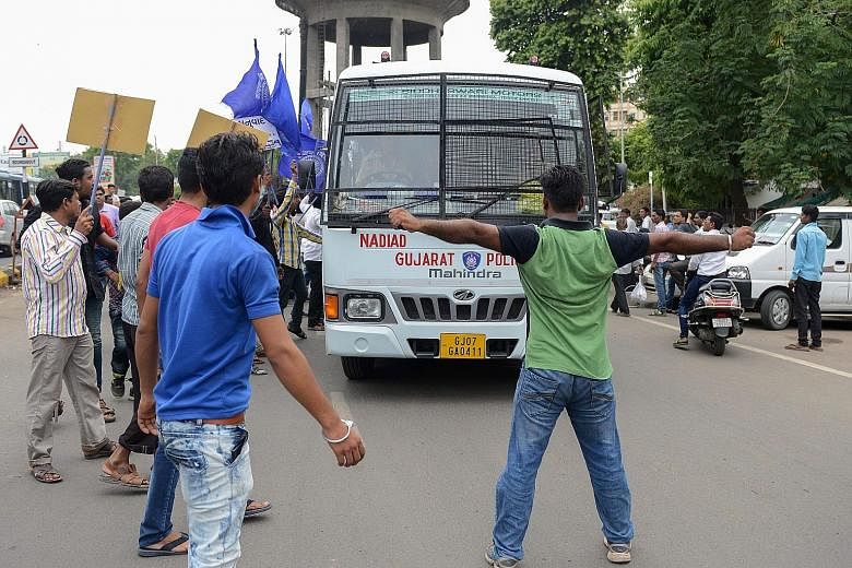 Members of a Dalit activist group protesting in the Gujarat town of Una on Tuesday after four low-caste Dalit men accused of skinning a dead cow were beaten up by "cow vigilantes" there last week. The beatings are a serious setback for Prime Minister