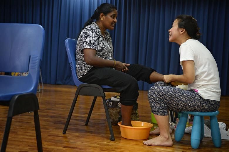 Malaysian cleaner Nagamah Jayaramm (above) gets to put her feet up and be pampered by volunteer Yunn Chee. 