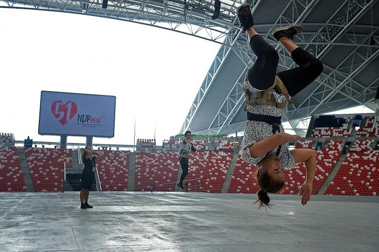 Above: Aerialists Wayne Wee, Rajid Ahamed and Biwa Mastura Mohamed Said have undergone intensive training since May. Above left: Ms Biwa and the MDC unit rehearsing at the National Stadium for the first time.