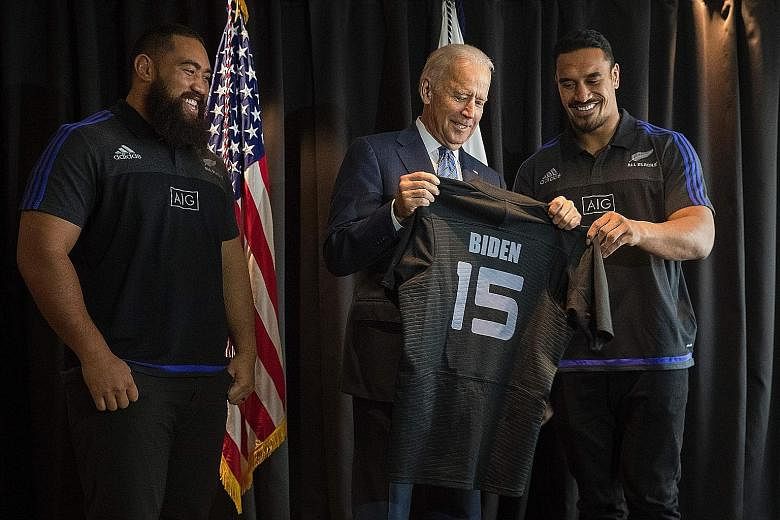 US Vice-President Joe Biden receiving a personalised All Blacks rugby jersey from New Zealand rugby stars Jerome Kaino (right) and Charlie Faumuina during his visit to Auckland yesterday.