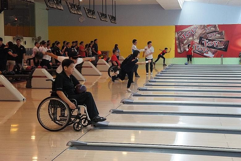 National para bowlers Thomas Ong (foreground) and Kalvin Tay (in red) roll off against donors in the inaugural Charity Bowling Challenge hosted by Sponzer, a branding agency founded by Asian Games triple gold medallist Remy Ong. The event, which was 