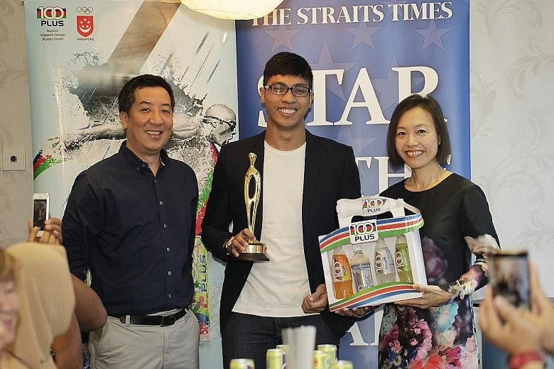 ST sports editor Marc Lim and F&N general manager Jennifer See presenting June's ST Star of the Month award to silat exponent Alfian Juma'en.