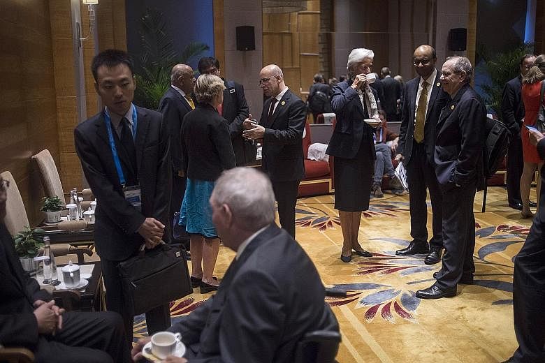 International Monetary Fund managing director Christine Lagarde (third from right) chatting with Singapore's Deputy Prime Minister Tharman Shanmugaratnam (second from right) and Italy's Finance Minister Pier Carlo Padoan (right) before the start of t