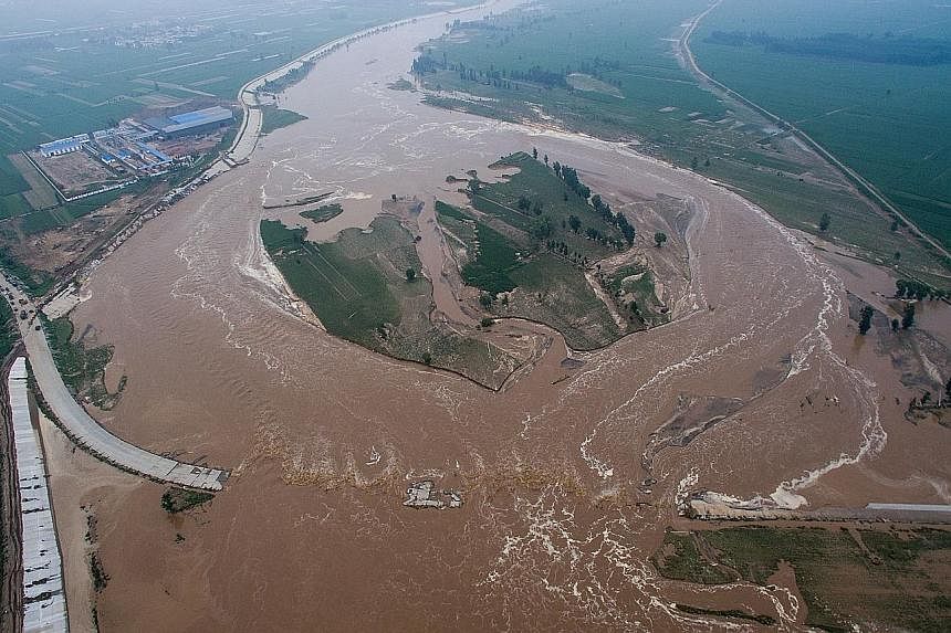 Muddy water gushing over roads and fields in Xingtai. The reason for the flood remains unclear, though some suspect a broken levee.